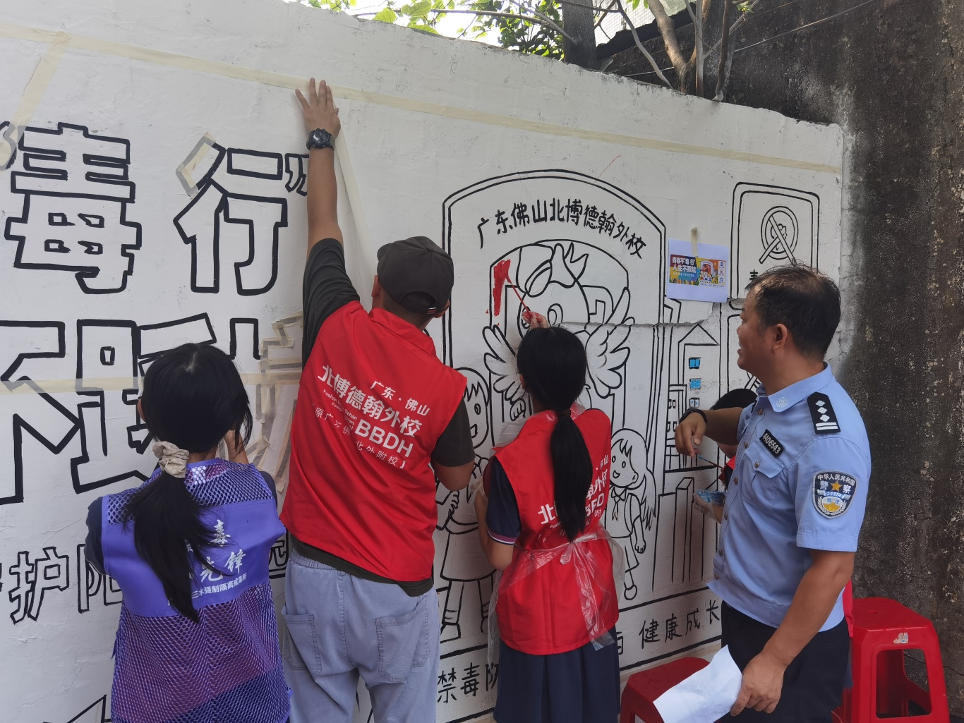 民警与师生共同绘制墙绘4.jpg