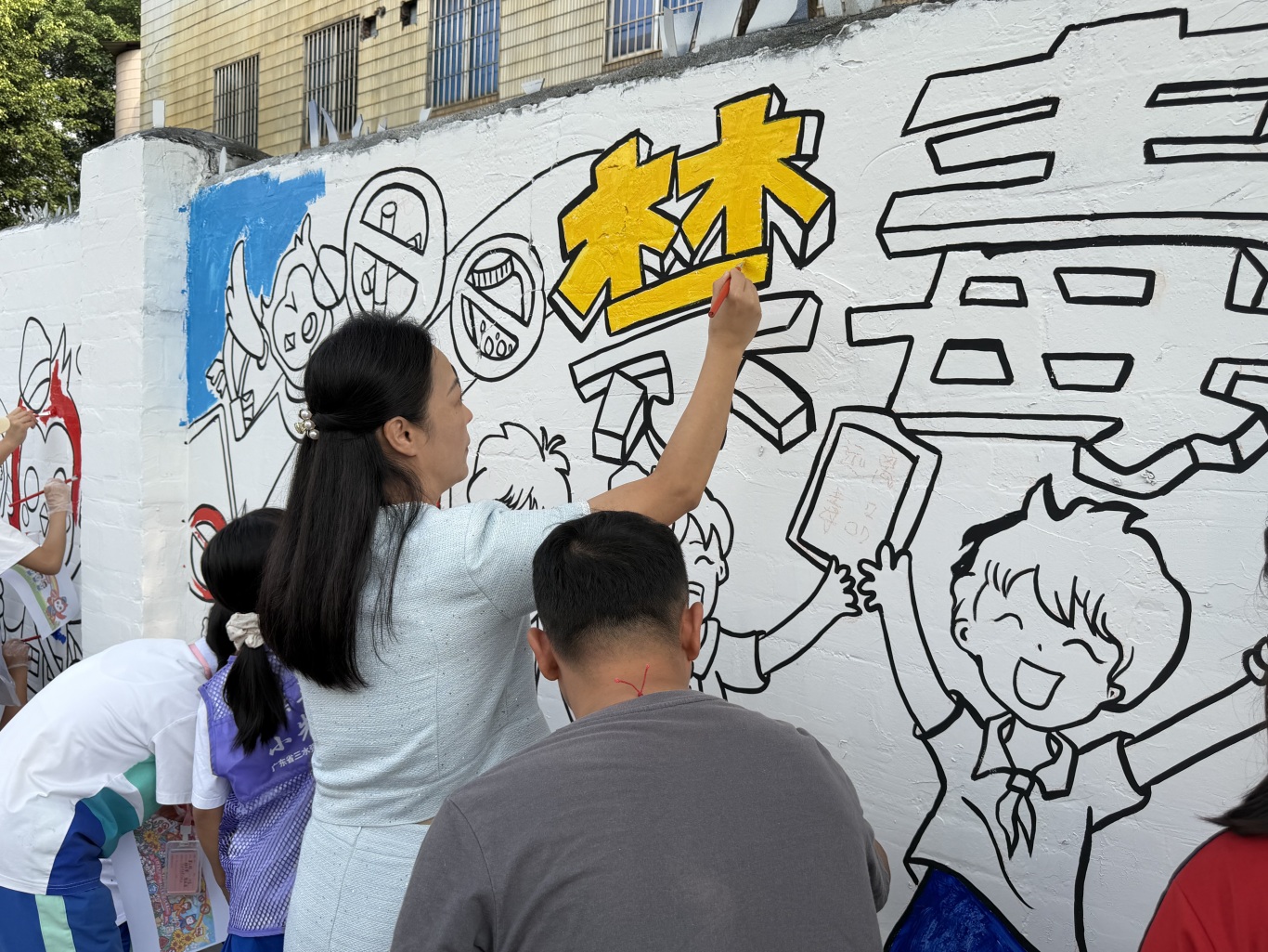 西南街道教育办袁主任参与墙绘创作.JPG