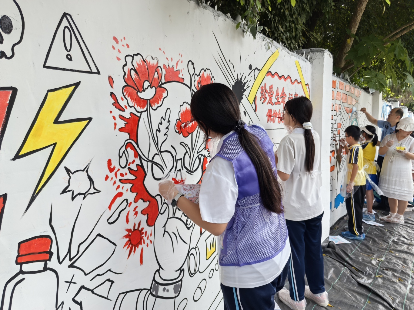 学生认真专注地为墙绘上色.jpg