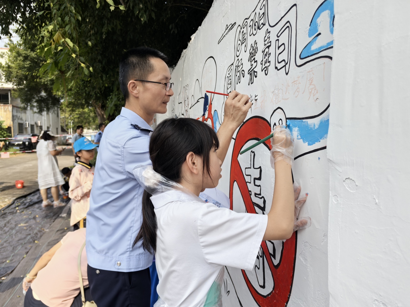 民警在墙绘上写下禁毒标语.jpg